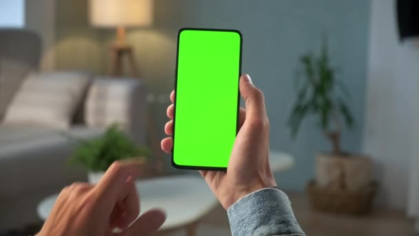 Modern Odada Bir Kadın Oturuyor Yeşil Model Ekran Krom Anahtarı ile Telefon Kullanıyor İnternet İzleme İçeriği Videoları Blog 'ları İzlemeden. Çifte Geçiş — Stok video