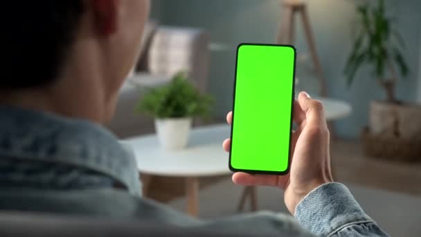 POV Вид человека на телефон с зеленым экраном для копирования пространства. Chromakey Mock Up With Tracking Markers. Мальчик 20-х годов смотрит видео новости на диване. Нажмите, чтобы нажать на центр экрана — стоковое видео