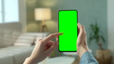 Telefondaki kadının POV görünümü ve kopyalama alanı için yeşil ekran. Chromakey İşaretlemesiz Mock Up. 20 'li yaşlardaki Bayan Kanepe Kapanış' ta Video Haberleri izliyor. Çifte Geçiş