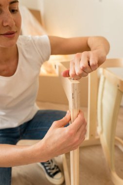 Mutlu Gülümseyen Çift Mobilya Toplar. Kız, Koltuk Detaylarını Toplamaya Yardım Ediyor. Yeni Apartman 'a taşınıyoruz, Genç Aile Mobilyaları Topla