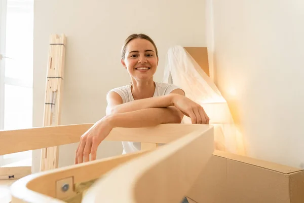 Glada leende par samlar möbler som ett lag. Flicka hjälper till att montera stolsdetaljer. Flyttar till Ny lägenhet, Ung Familj Montera Möbler — Stockfoto