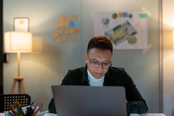 Educação, prazo e conceito de pessoas - close-up de homem criativo em óculos trabalhando no escritório da noite e pensando feliz asiático freelancer coreano homem laptop — Fotografia de Stock