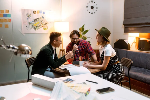 Een groep jonge ontwerpers kwam 's avonds samen op kantoor om ideeën te bespreken — Stockfoto