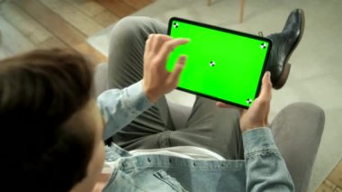 Green Mock-up Tablet Dijital Tablet Bilgisayarında Erkek Tutma ve El Hareketleri Kullanma Omuzundan Görünüm. Erkek Eşya Satın Alma ya da İnternet Taraması.