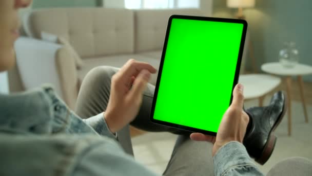 View From the Shoulder of Man Holding and Using Hand Gestures on Green Mock-up Screen Digital Tablet Computer Seitting on a Chair. Mužské nákupy nebo prohlížení. Klepnutí na prostřední obrazovku — Stock video