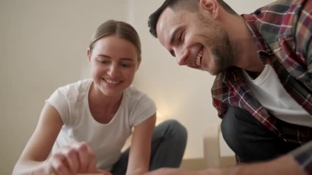 Adultos jóvenes mudándose a un nuevo hogar. Pareja moviéndose en el montaje de muebles de silla. Joven pareja interracial en un nuevo hogar. reparación, renovación y concepto de personas — Vídeos de Stock