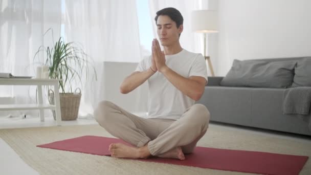 单身男子在家做瑜伽，闭着眼睛慢慢呼吸。家庭体育和健康的生活方式、活动、健身和锻炼。室内训练及家居练习 — 图库视频影像