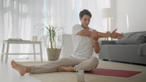 Mladý muž cvičí doma. Držte se za ruce a kolena na Józe Mat a zvednout jednu paži pokaždé během tréninku. Flexibilní krevní oběh těla — Stock video