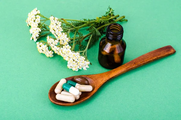 Herbal medical capsules, pills from medicinal plants on green background — Stock Photo, Image