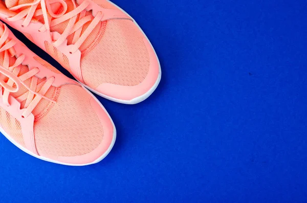Pair of sport pink shoes on colorful background. New running sneakers. Top view, flat lay