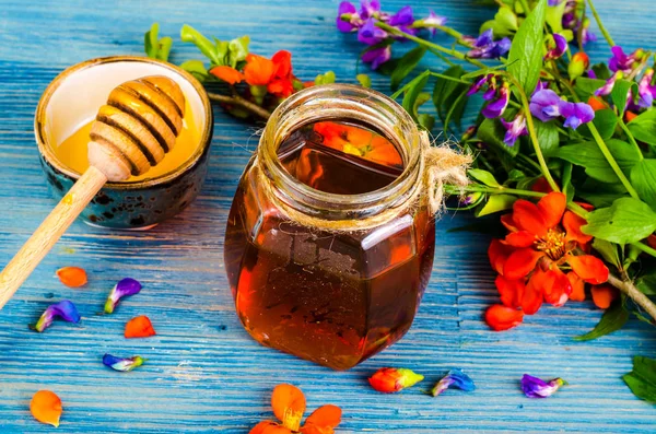 Honey from summer meadow flowers on blue wooden background — Stock Photo, Image