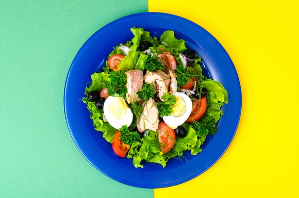 Prato azul com salada de peixe sobre fundo brilhante — Fotografia de Stock
