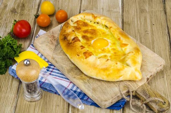 치즈와 달걀 나무 보드에 뜨거운 khachapuri — 스톡 사진