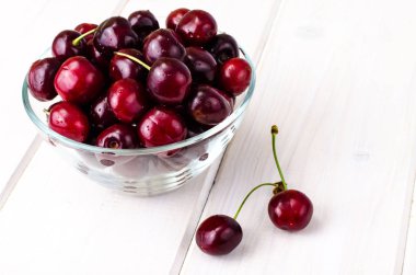 Masada bir kapta olgun burgundy kiraz. Studio fotoğraf