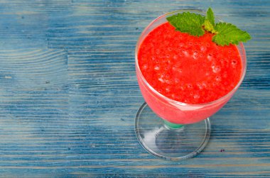 Cam mavi ahşap masa üzerinde pembe meyve smoothies ile. Studio fotoğraf