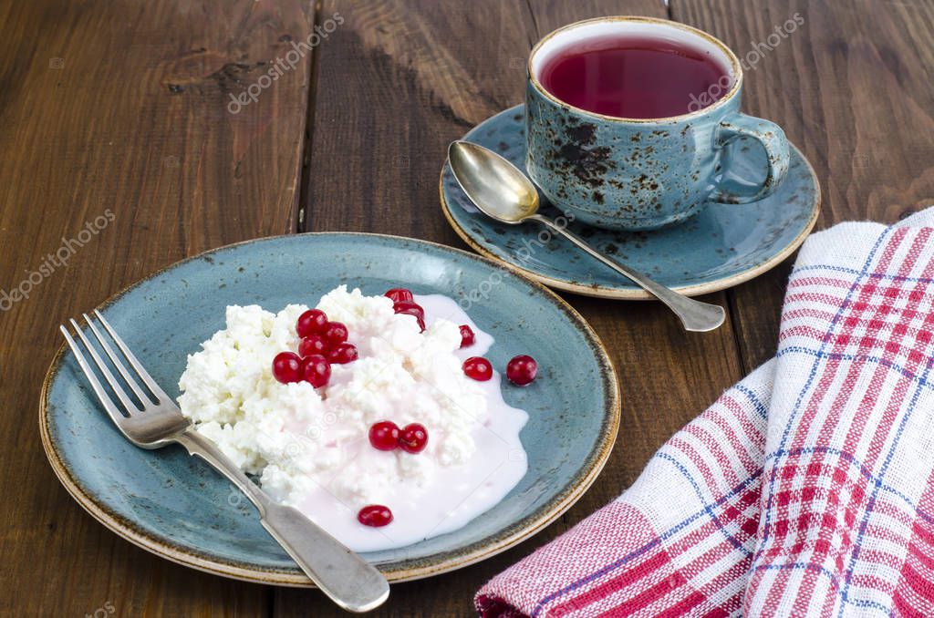 Homemade fresh cottage cheese with yogurt and red berries, tea. Studio Photo