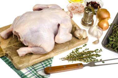 Çiğ tavuk eti üzerinde kesme tahtası, baharat ve sebzeler ile hazırlanan yemek için beyaz arka plan. Studio fotoğraf