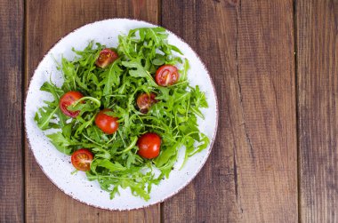 Roka ve domates hafif diyet salata ile plaka. Studio fotoğraf