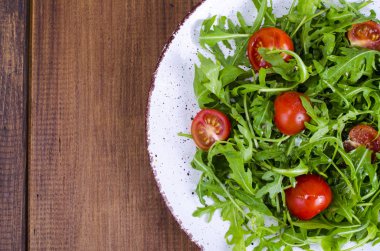 Roka ve domates hafif diyet salata ile plaka. Studio fotoğraf