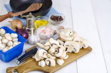 Mutfak masasının üzerinde tavada beyaz taze dilimlenmiş petrol. Mantar kullanacağını pişirme kavramı. Studio fotoğraf