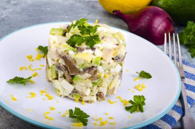 Tasty salad with squid and avocado on blue background. Studio Photo