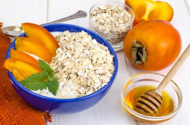 Yulaf ezmesi, yoğurt ve Trabzon hurması ile sağlıklı vejetaryen kahvaltı. Studio fotoğraf