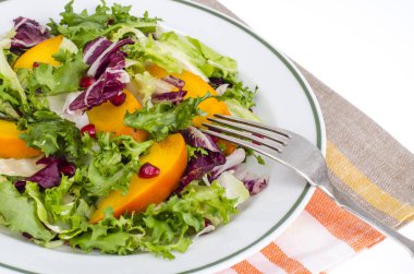 Salatası yeşil yaprakları ve Trabzon hurması. Stüdyo Phot