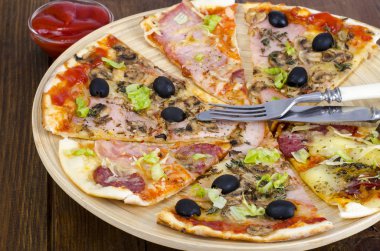 Altı dilim pizza ahşap tahta üzerinde farklı Topingler ile. Studio fotoğraf