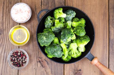 Yemek pişirmek için donmuş brokoli ile dökme demir tava. Studio fotoğraf