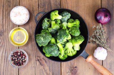 Yemek pişirmek için donmuş brokoli ile dökme demir tava. Studio fotoğraf