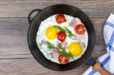 Kızarmış yumurta, pastırma ve domates ile kızartma tavası. Stüdyo Phot