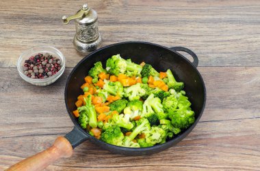 Vejetaryen yemek. Brokoli, havuç, tavada yeşil bezelye. Studio fotoğraf