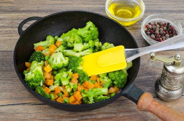 Vejetaryen yemek. Brokoli, havuç, tavada yeşil bezelye. Studio fotoğraf