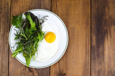 Kahvaltı için tabak kızarmış yumurta ve yeşil salata yaprakları. Studio fotoğraf