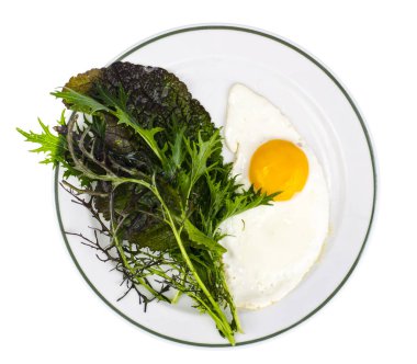 Kahvaltı için tabak kızarmış yumurta ve yeşil salata yaprakları. Studio fotoğraf