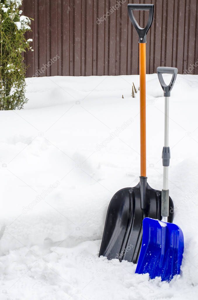 Blue snow shovel in winter. Studio Photo