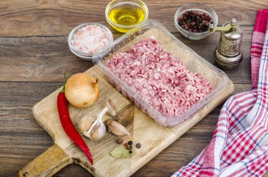 Çiğ kıyma ile ahşap tahta üzerinde yemek pişirmek için baharat. Studio fotoğraf