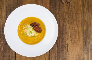 Kabak crem çorba ve ahşap arka plan üzerinde kurutulmuş domates ile plaka. Studio fotoğraf