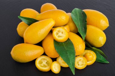 Siyah arka plan üzerine parlak turuncu kumquats. Studio fotoğraf