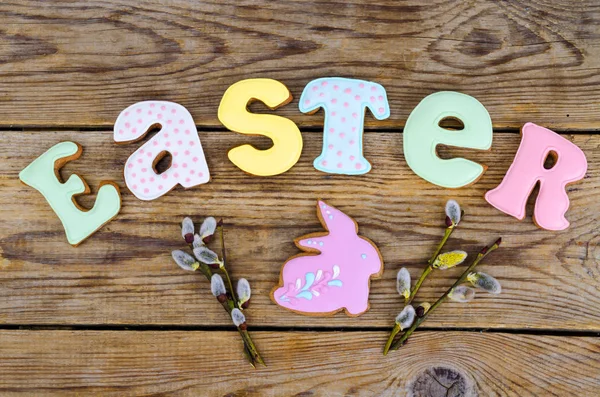 Galletas caseras en forma de letras Pascua y huevos sobre fondo de madera vieja . — Foto de Stock