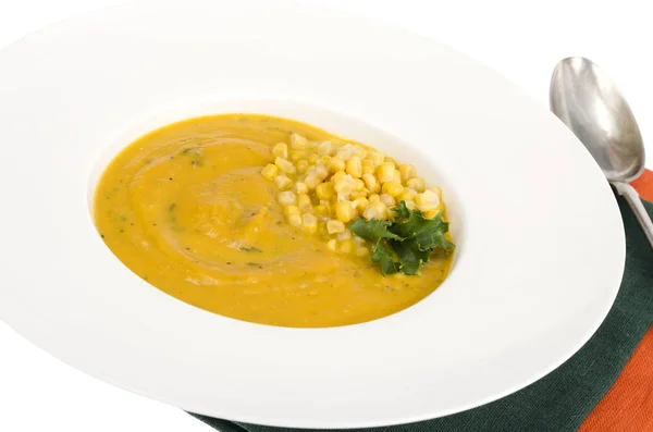 White plate with corn mash soup