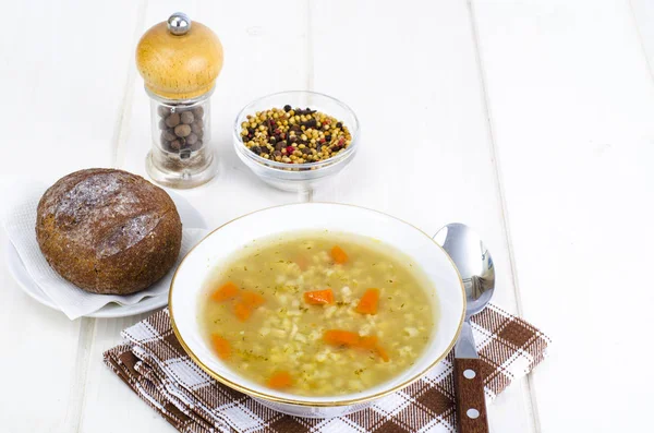 Vegetable broth with brown rice and carrots. — Stock Photo, Image