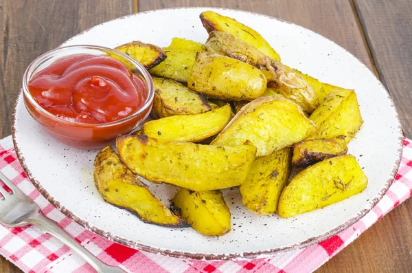 Cuñas de papa al horno con hierbas de estilo rústico en el plato —  Fotos de Stock