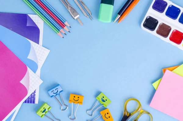 Ritorno a scuola con accessori per la scuola - pitture, matite, quaderni, forbici, pennarelli, sfondo blu . — Foto Stock