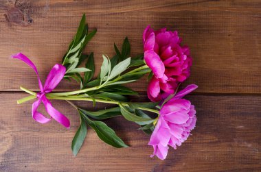 Ahşap masa üzerinde kurdele ile iki güzel şakayık