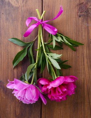 Ahşap masa üzerinde kurdele ile iki güzel şakayık