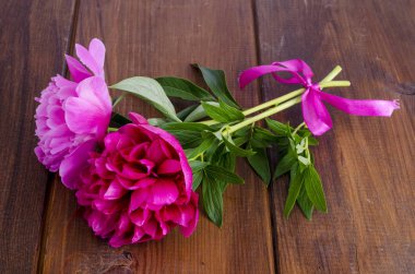 Ahşap masa üzerinde kurdele ile iki güzel şakayık