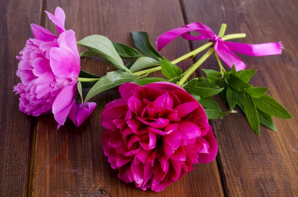 Ahşap masa üzerinde kurdele ile iki güzel şakayık