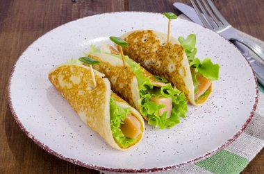 Krep, somon ve yeşil salata yapraklarından atıştırmalık rulolar. 