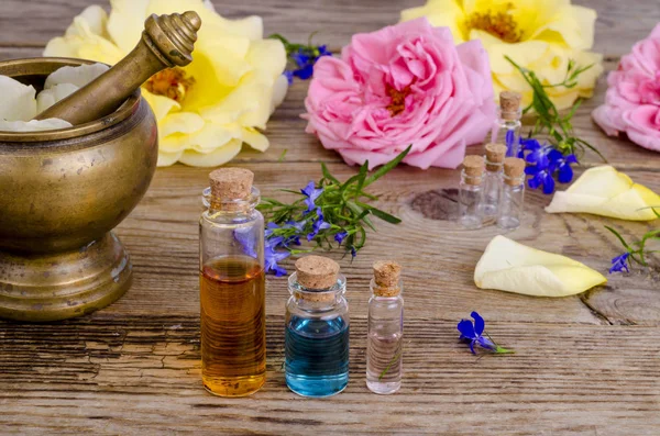 Bottle of essential oil for aromatherapy with fresh rose flowers. — Stock Photo, Image